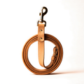 Coiled tan leather dog leash with brass hardware
